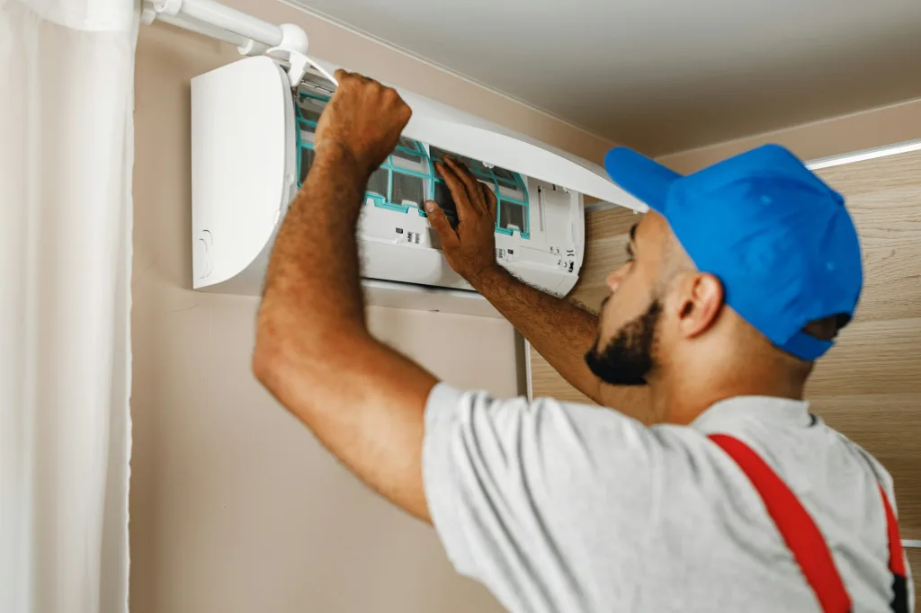 Professional repairman installing air conditioner in a room